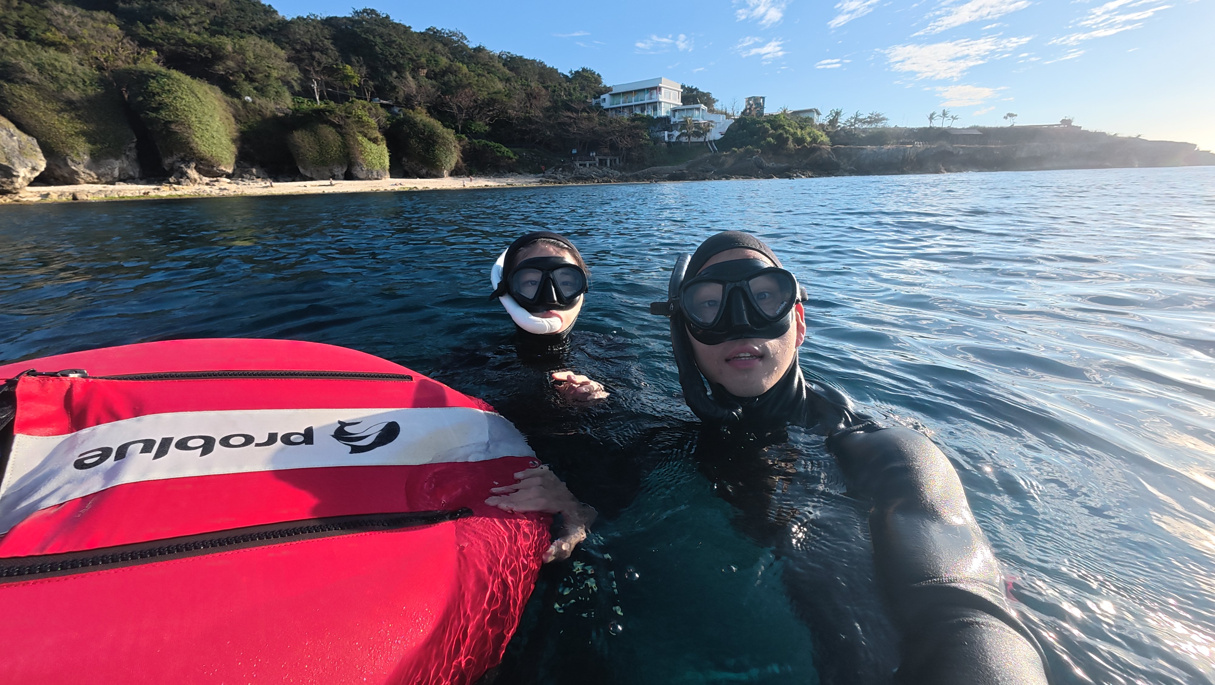 Two freedivers surfacing together near the shore